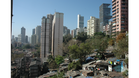 Informal settlement next to high rises in a city.