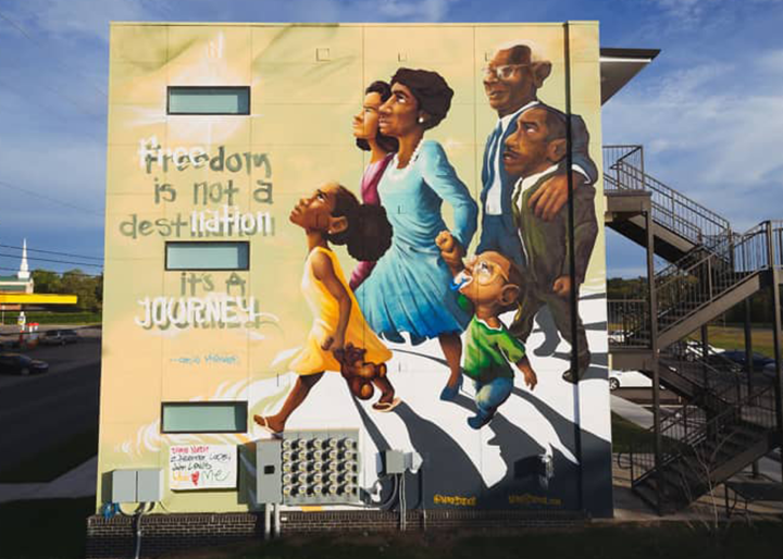 Mural of a family walking and looking up next to the words: Freedom is not a destination it's a Journey