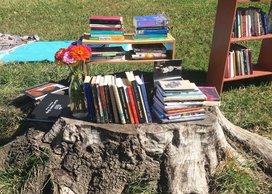 books stacked on a tree stump.